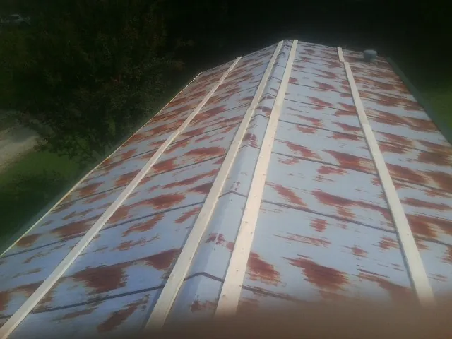 Rusted metal roof panels with new wood purlins before replacement — Storm Damage Roof Repair in Hickory Hills by Roofing Brothers