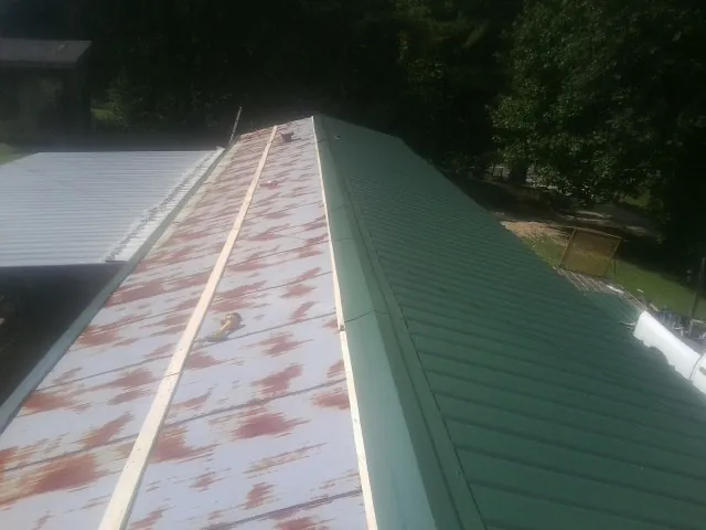 Old rusted panels beside newly installed green metal roofing — Wind Damage Roof Repair by Roofing Brothers in Hickory Hills