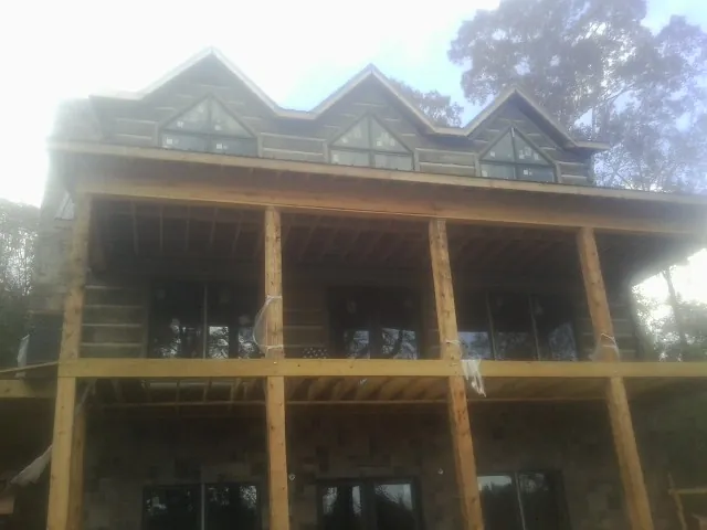 Dormers and porch framing on a large log home under construction — Roof Coating work by our crew in Hickory Hills