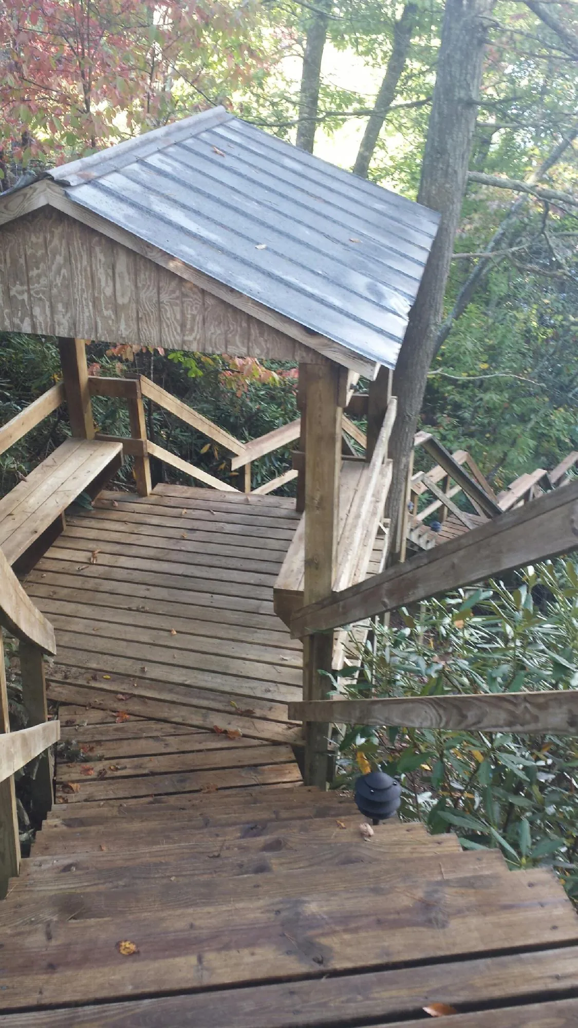 Metal roofed shelter over wooden steps on a wooded walkway — Skylight Repair & Installation work by our crew in Hickory Hills